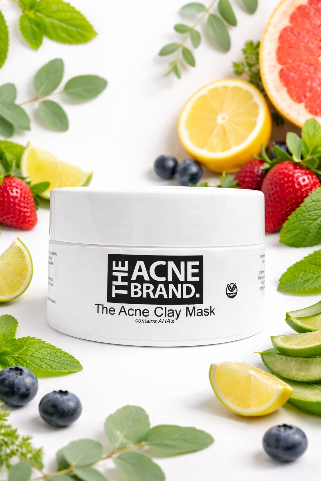The Acne Serum from the plant-based acne skincare range on a marble surface with fruits and leaves.